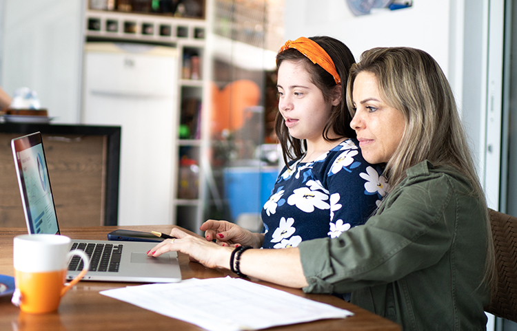 A parent and their child looking at a laptop.